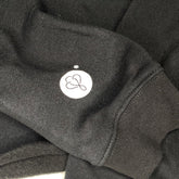 Showcasing the sleeve of the BIG LOViE CREWNECK SWEATSHIRT BLACK with logo detail and soft fabric texture.
