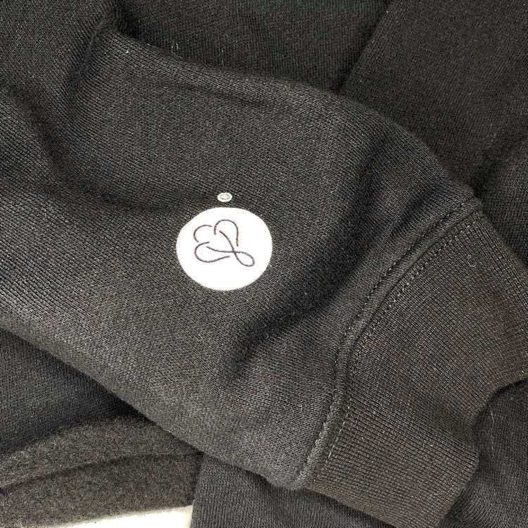 Showcasing the sleeve of the BIG LOViE CREWNECK SWEATSHIRT BLACK with logo detail and soft fabric texture.